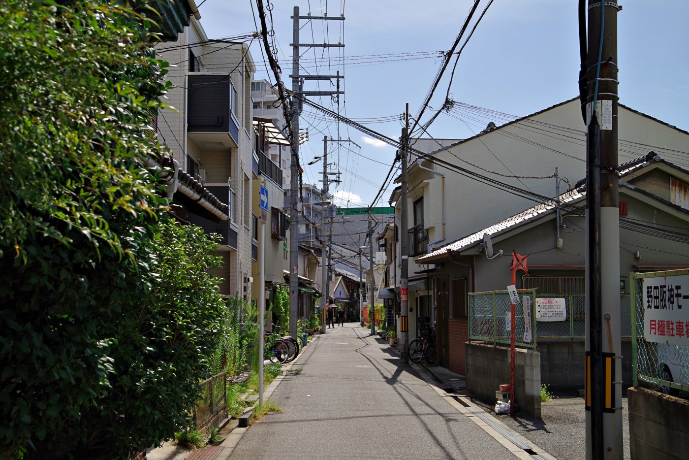 電柱が並ぶ下町の細い道と古い住宅