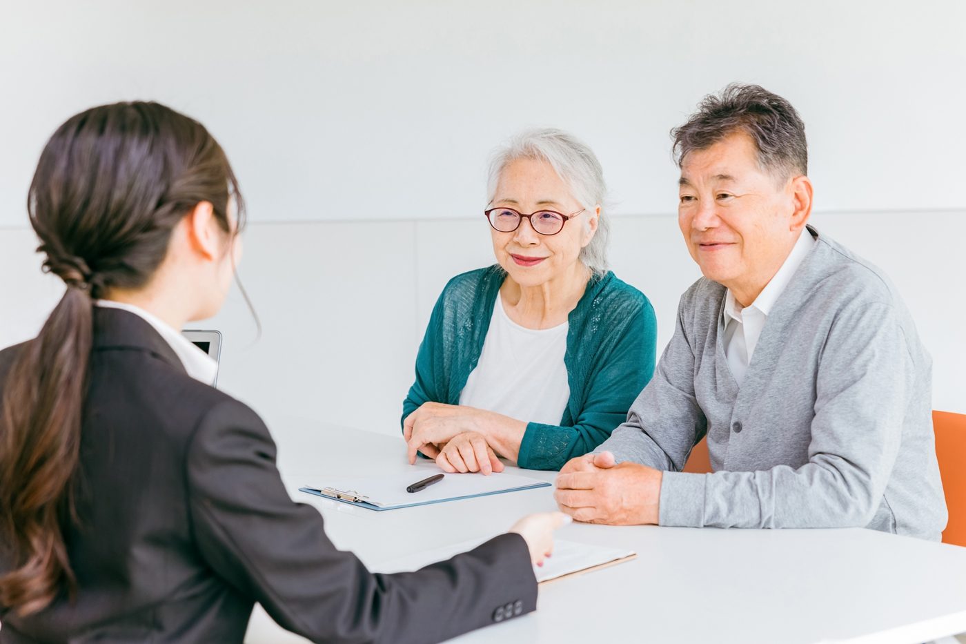 担当者が資料を示し、高齢のご夫婦が話を聞いている様子