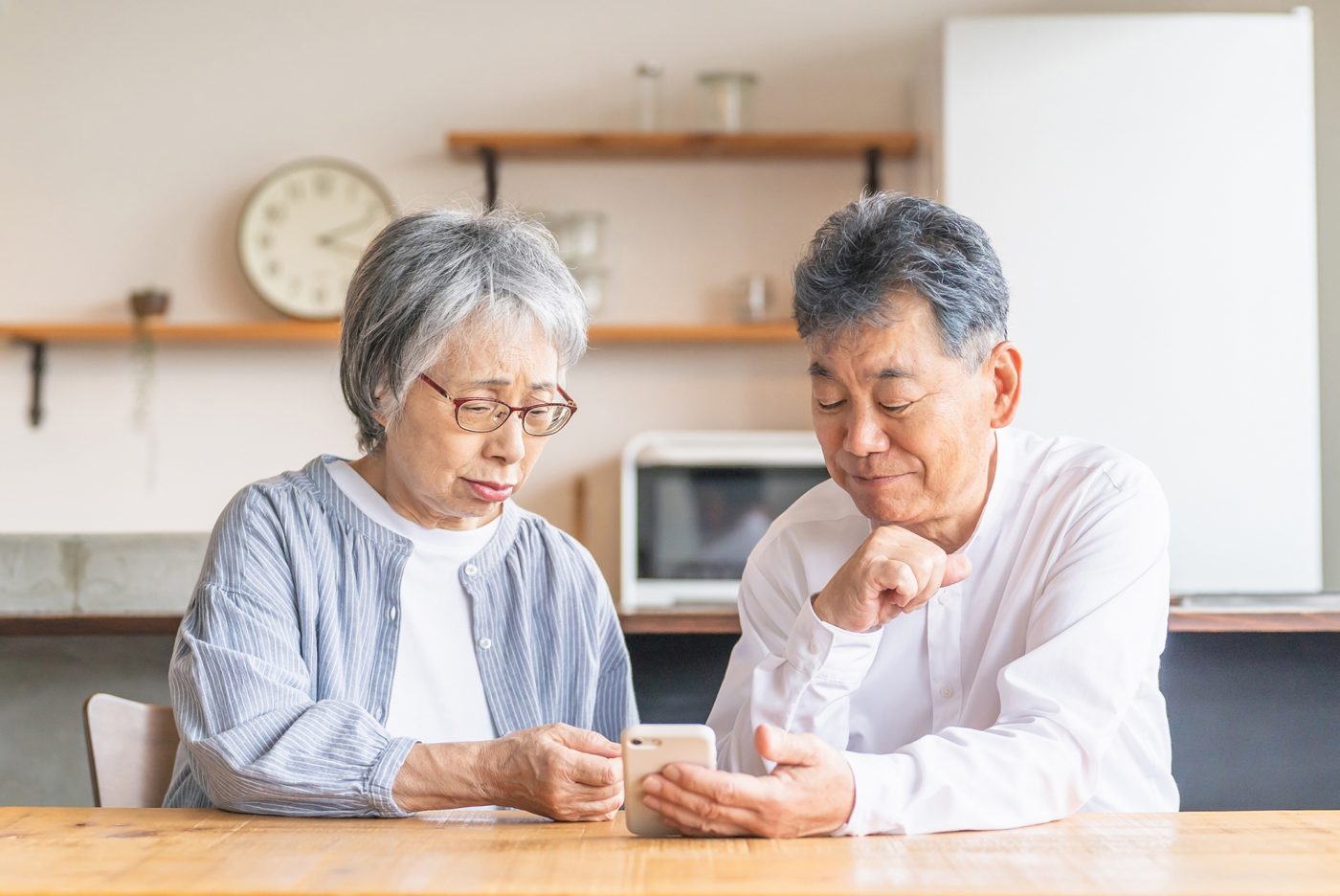 高齢のご夫婦が自宅のテーブルで今後のことを話し合っている様子