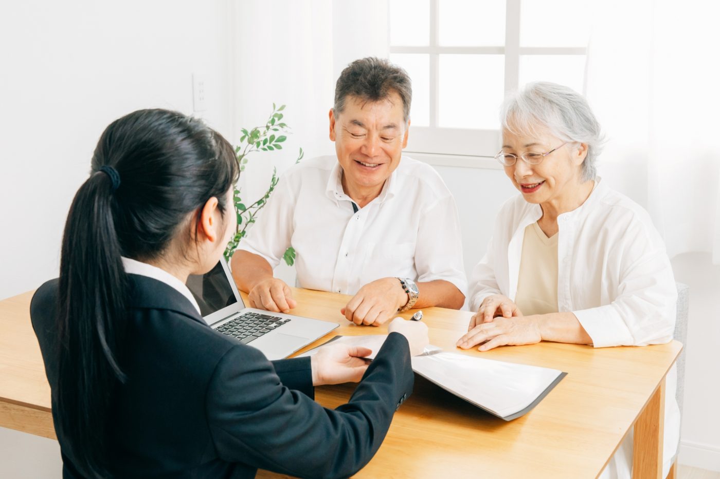 担当者が高齢のご夫婦に書類を見せながら説明している様子