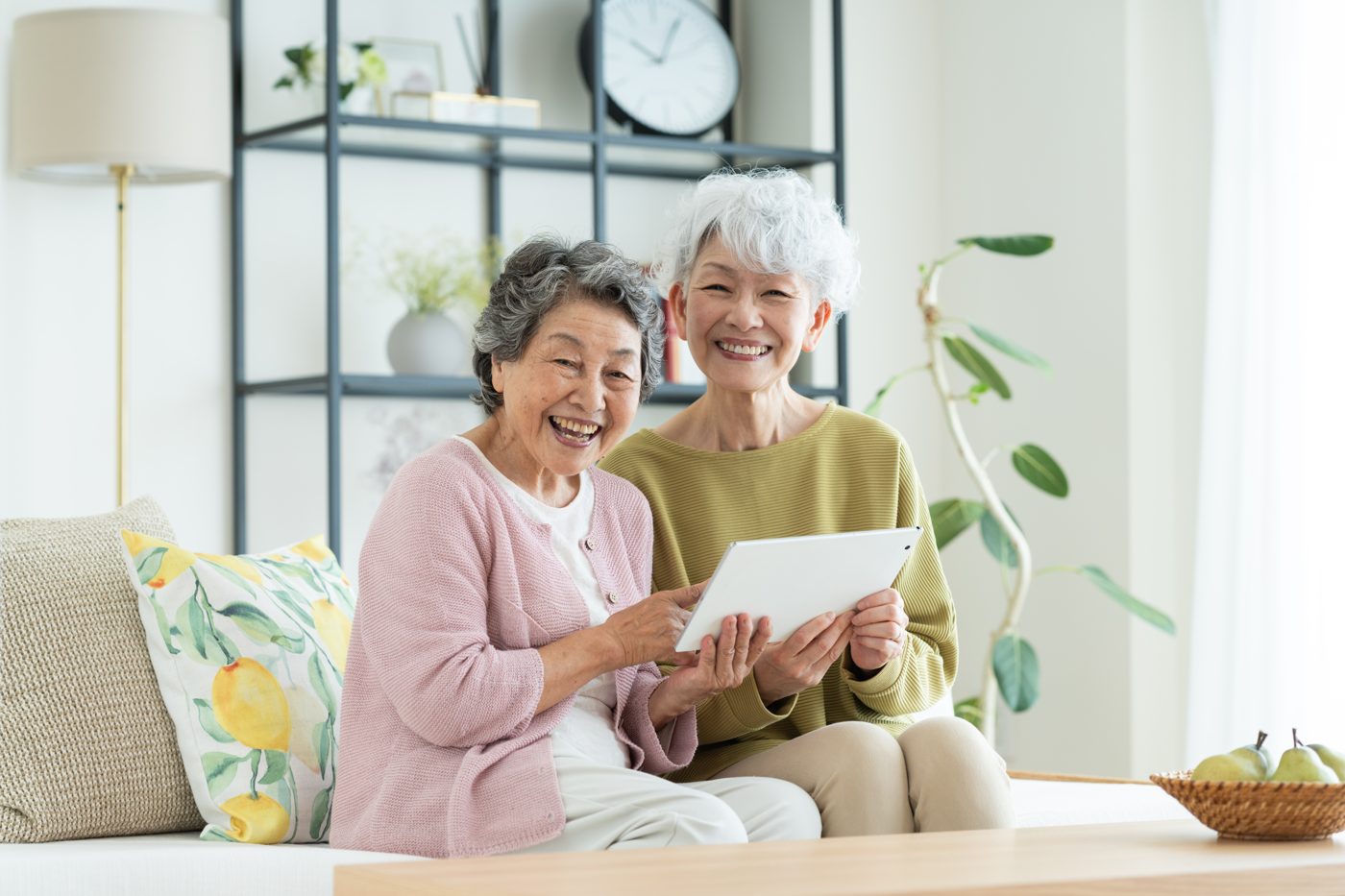タブレットを見ながら話す高齢の姉妹